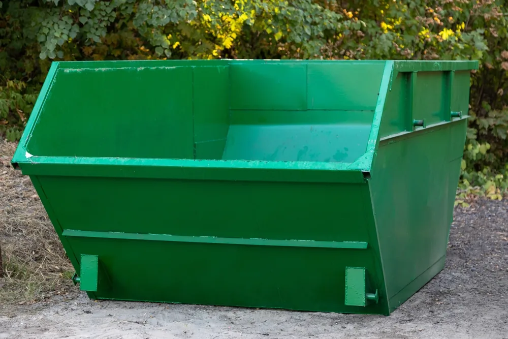 Benne à gravats verte proposée à la location par JDM Couvreur